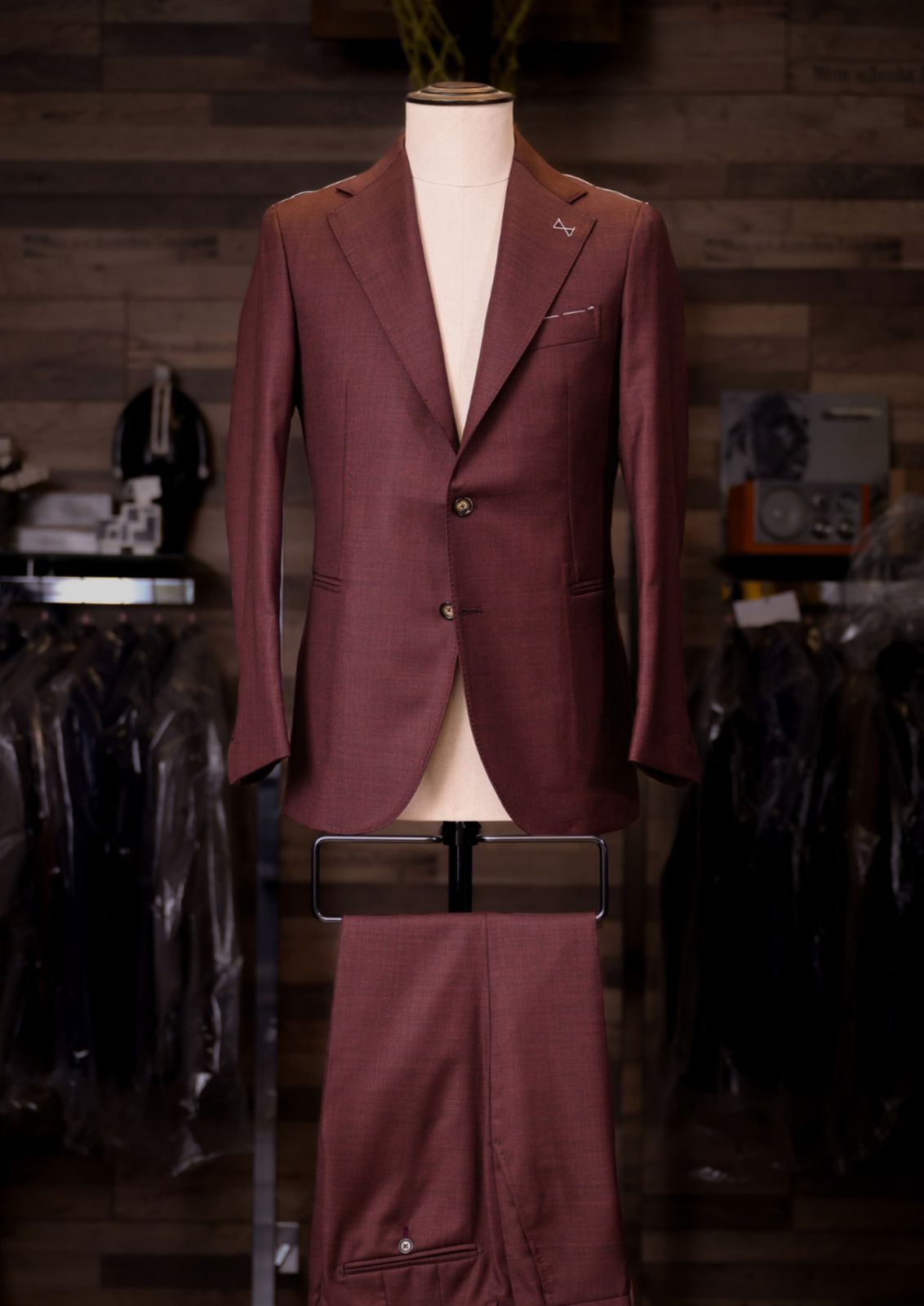 Oxblood burgundy single-breasted Carelli suit on a tailor's mannequin