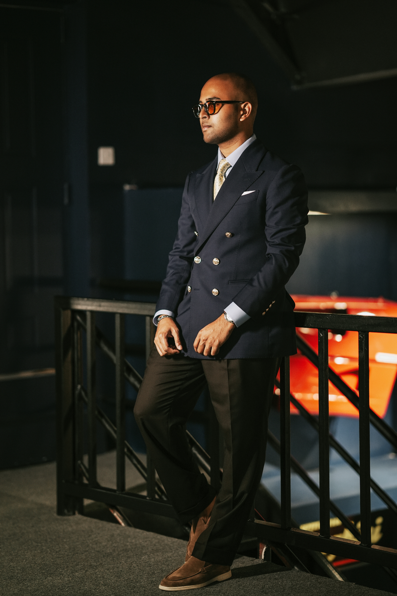 Client in navy double-breasted blazer and brown trousers on a staircase