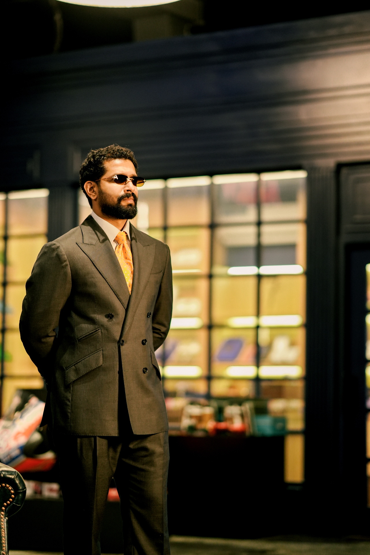 Model wearing a double-breasted Carelli suit in a dark interior