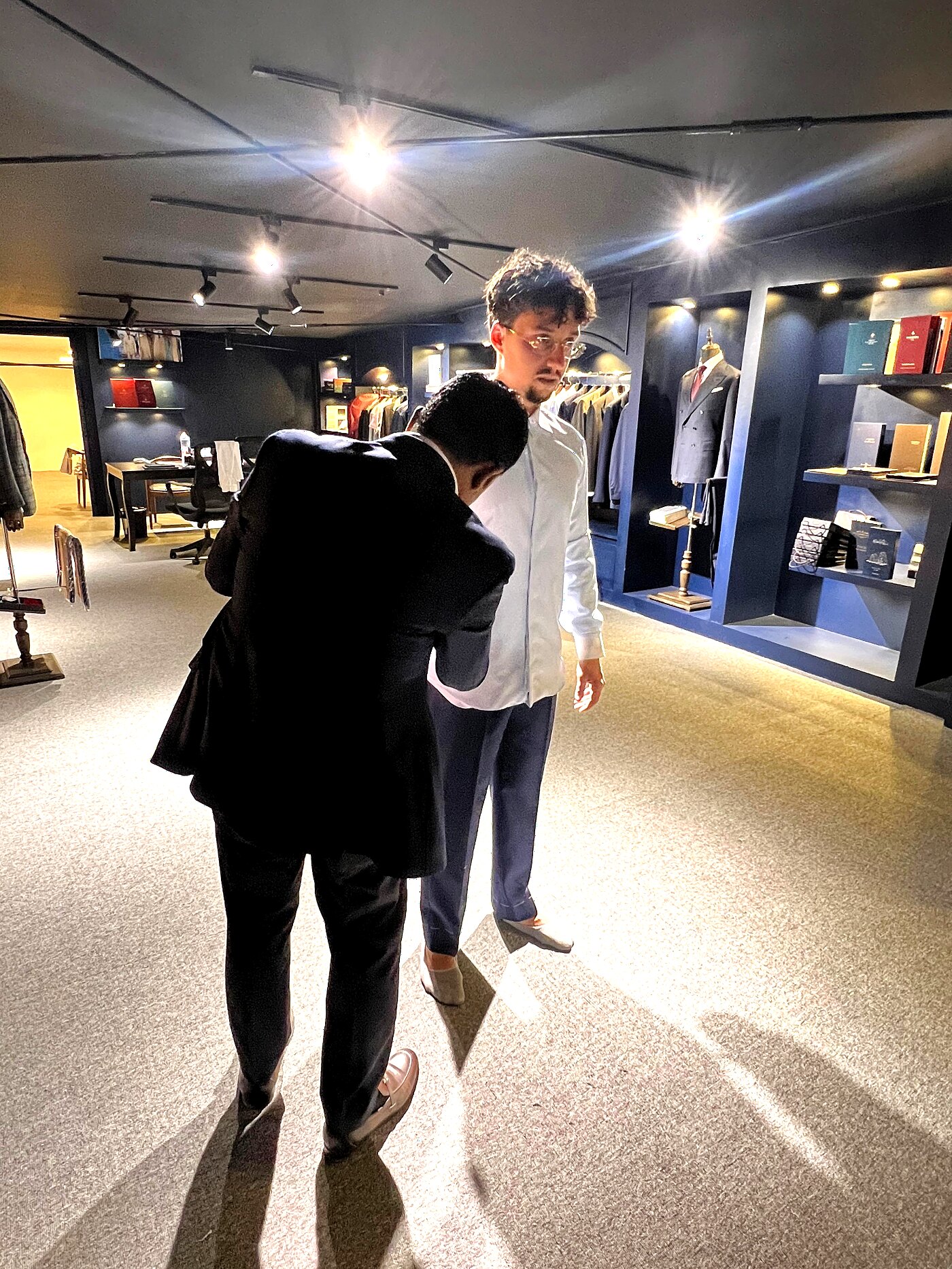 Tailor checking trouser break and hem on a standing client