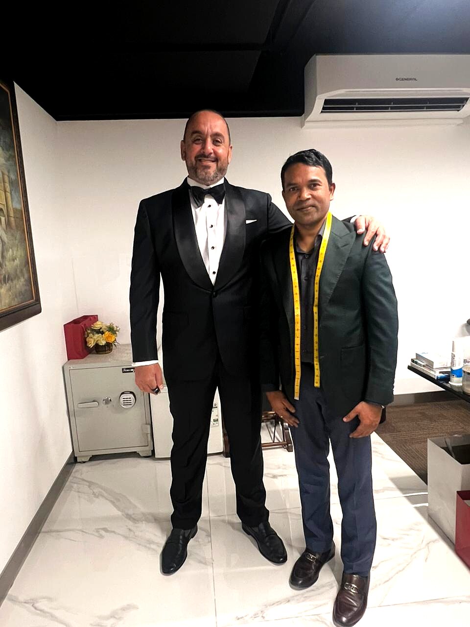 Client in a finished shawl-lapel tuxedo standing with the Carelli master tailor