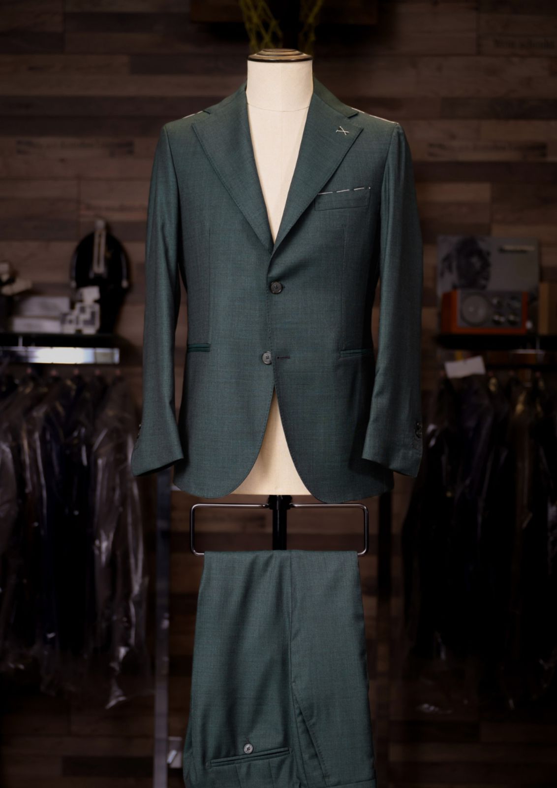 Forest green single-breasted Carelli suit on a tailor's mannequin